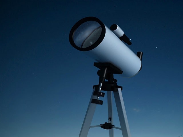 Telescope set up outdoors at dusk