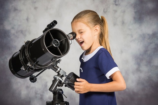 Child looking into telescope