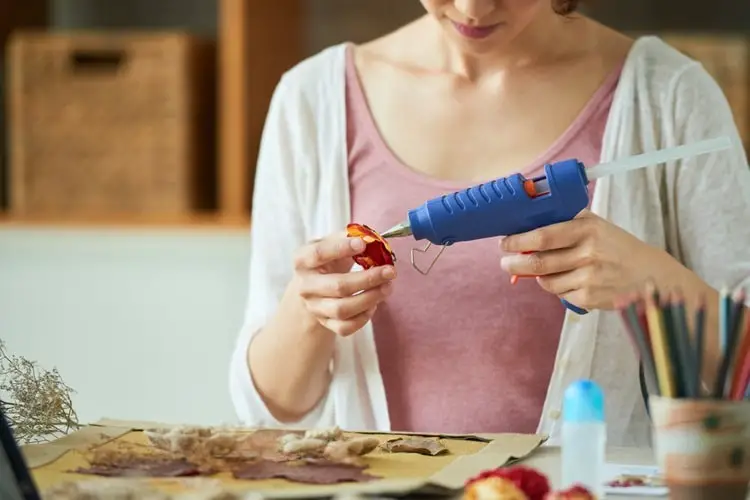Woman using a hot glue gun for a craft project