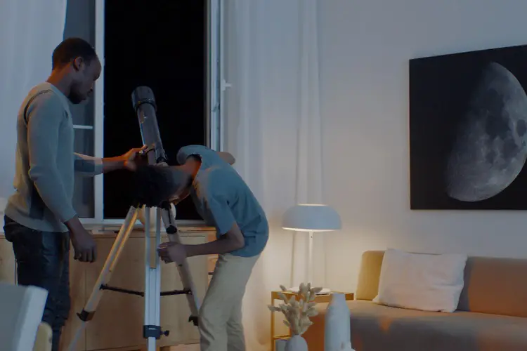 Parent and child using a telescope at home
